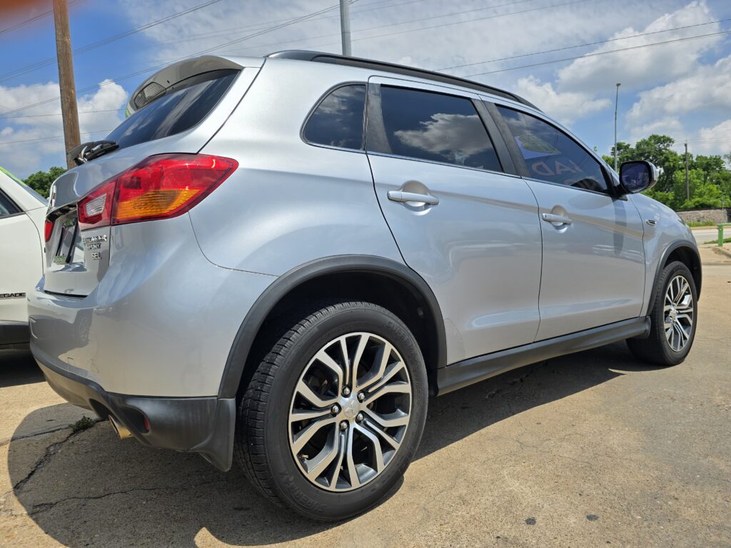 Close-up of a silver SUV showing the rear side and large alloy wheel on a sunny day.