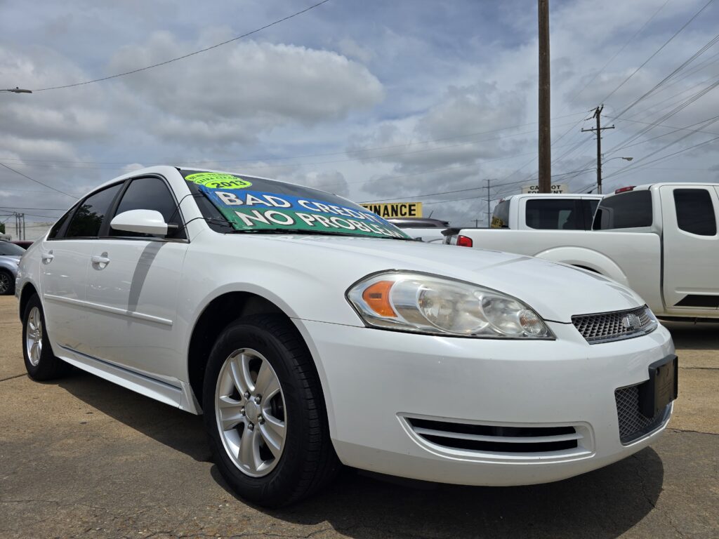 White sedan in a dealership lot with a bright green banner on the windshield reading 'BAD CREDIT NO PROBLEM'