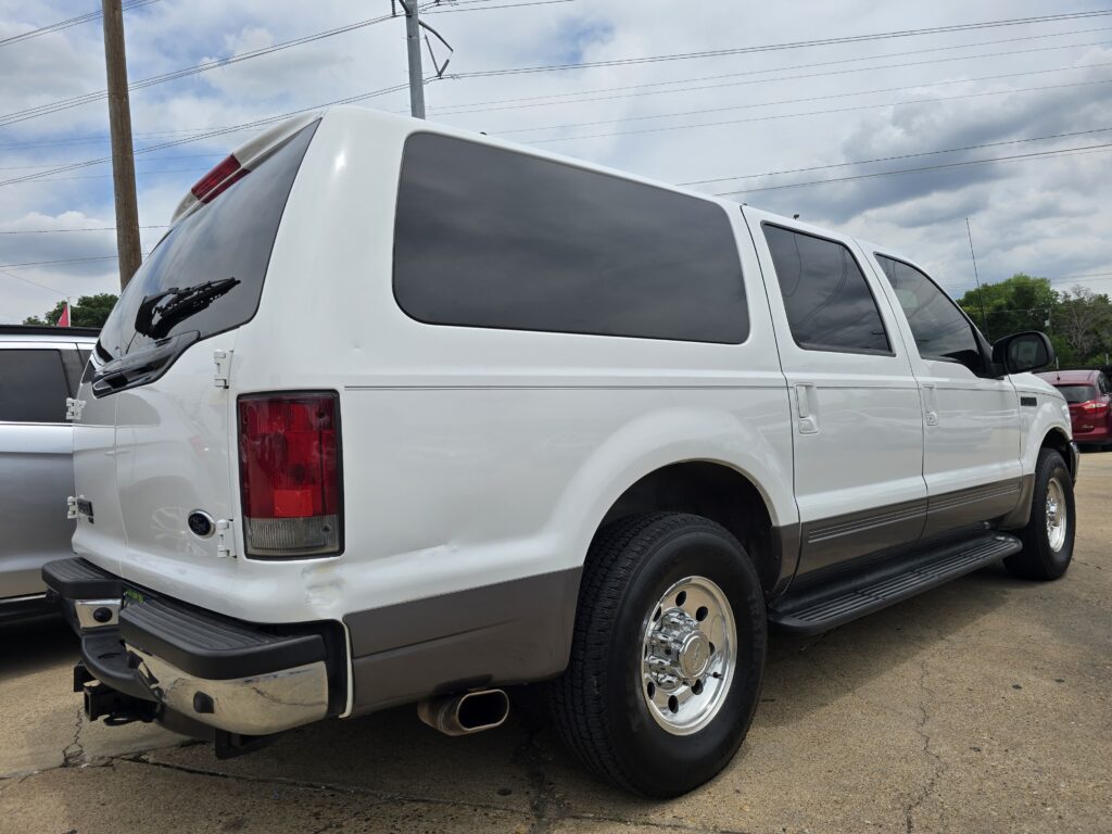 White cargo van parked, rear and side windows tinted, showing large wheel and exhaust.