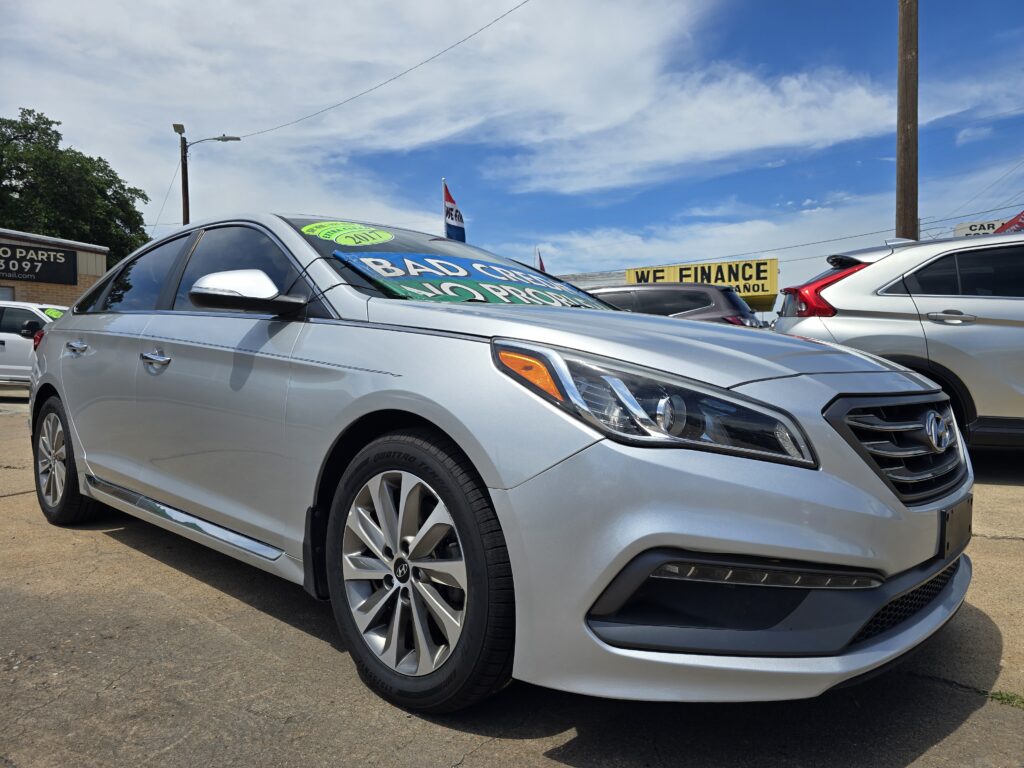 Silver Hyundai sedan in a used-car lot with green sale banners on the windshield and a 'WE FINANCE' sign in the background.