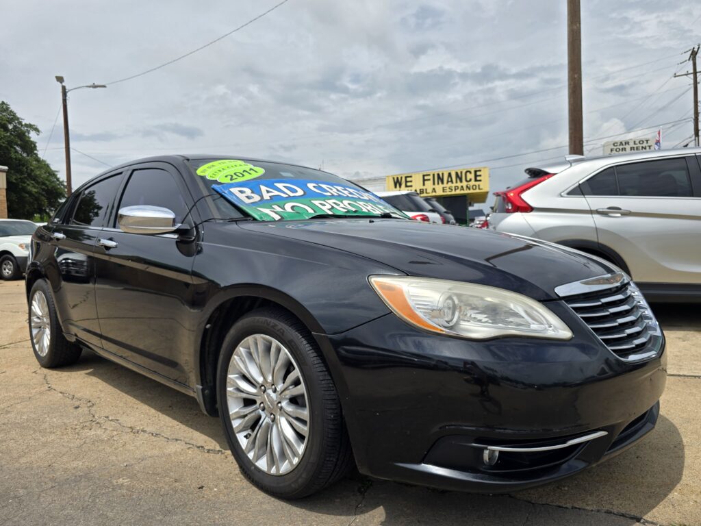 Close-up of a black SUV in a car dealership lot, with large green and blue signs on the windshield that say 'Bad Credit No Problem' and a 2011 sticker.