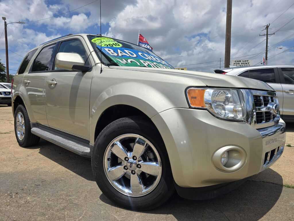 Front-left view of a beige SUV with large dealership windshield signs advertising bad credit and financing patterns on the glass.