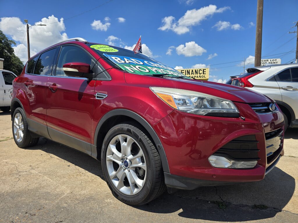 Red Ford SUV shown from the front-left on a used-car lot, with a bright green promotional banner on the windshield and a blue sky above.