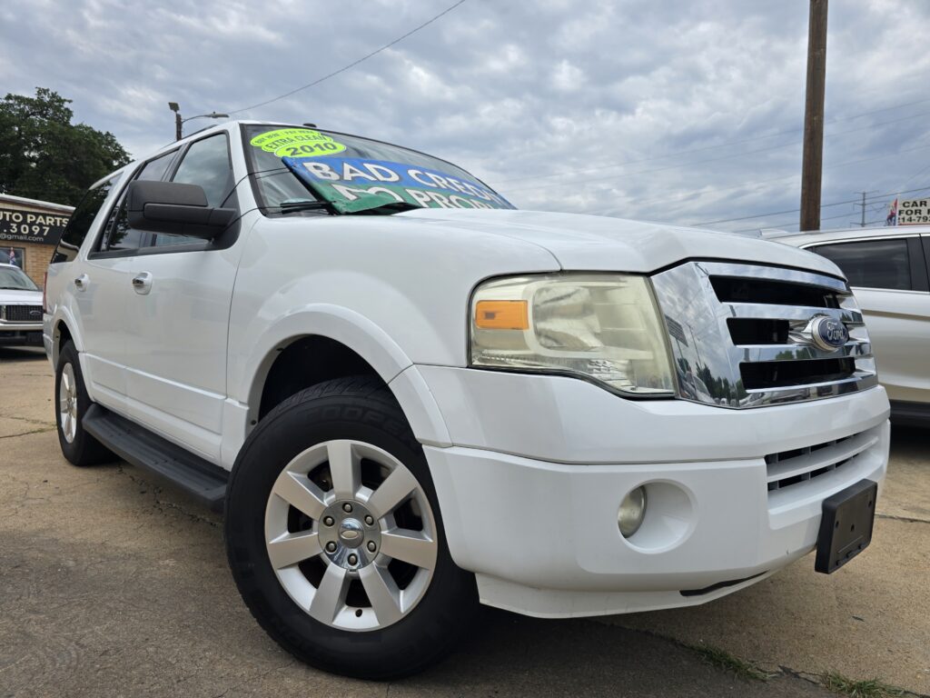 White Ford SUV on a dealership lot with a bright windshield sign reading 'Bad Credit' in blue and green letters.