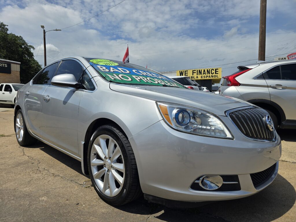 Silver sedan in a car dealership lot with large windshield banners reading 'Bad Credit No Problem' and a nearby 'We Finance' sign in the background.