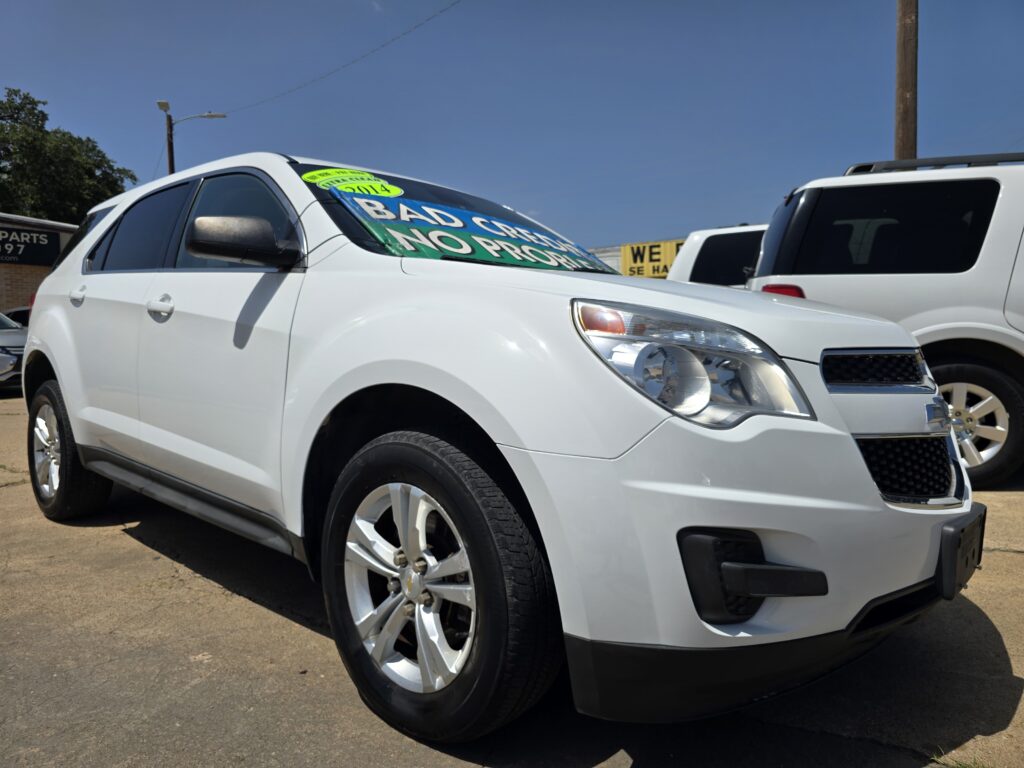 White SUV with a bright green banner on the windshield that reads 'BAD CREDIT NO PROBLEMS' in a car lot with other vehicles nearby (2014).