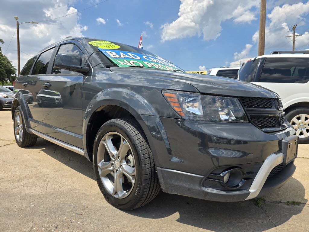 Gray SUV on a dealership lot with bright sale signs on the windshield and a 2017 sticker.