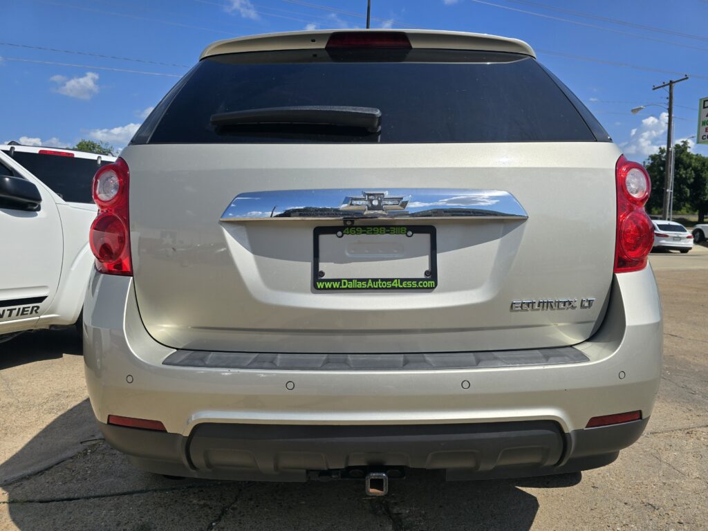 Rear view of a silver Chevrolet Equinox LT, with a DallasAutos4Less license plate frame and visible hitch.