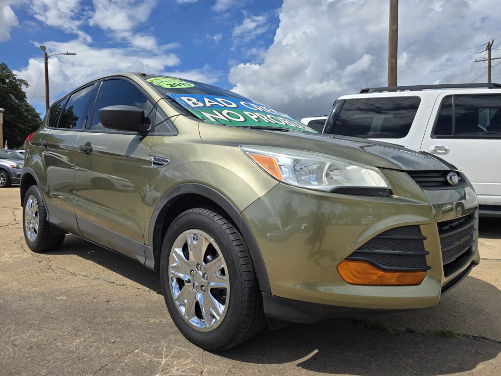 Beige SUV parked in a lot with a large blue-green sign covering the windshield.
