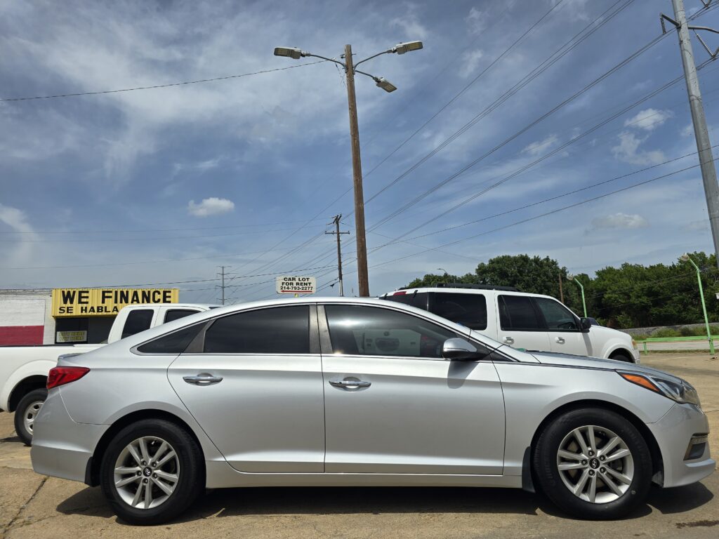 Silver SUV parked in a car lot with a yellow 'WE FINANCE' sign in the background.