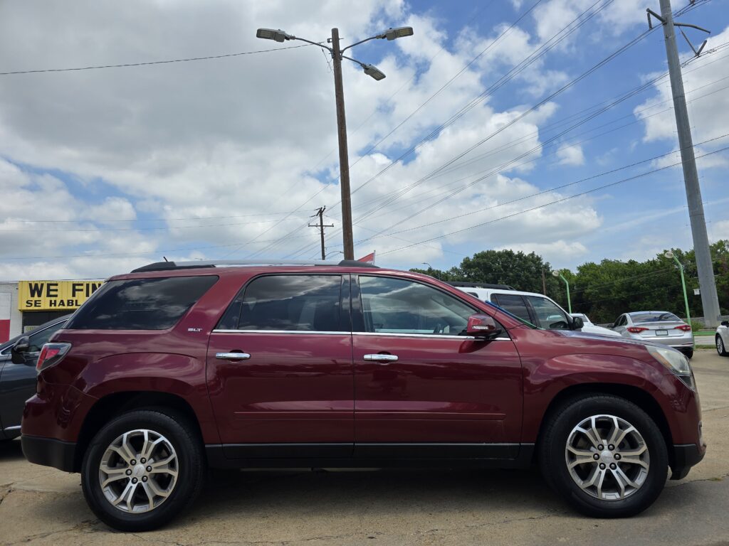 Red SUV parked in a lot with utility poles, power lines, and a partly visible yellow sign in the background against a blue sky.