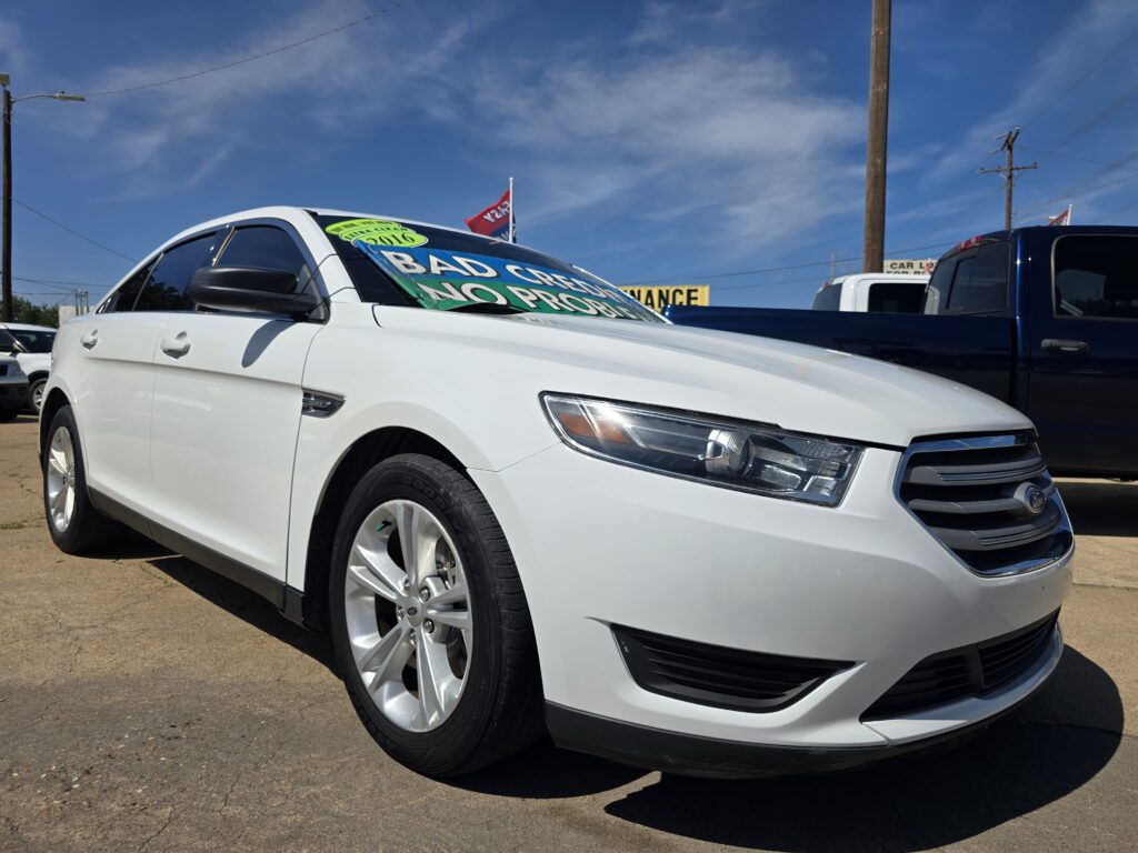 White Ford SUV at a used-car lot with bright green '2016' and 'Bad Credit? No Problem' windshield signs.