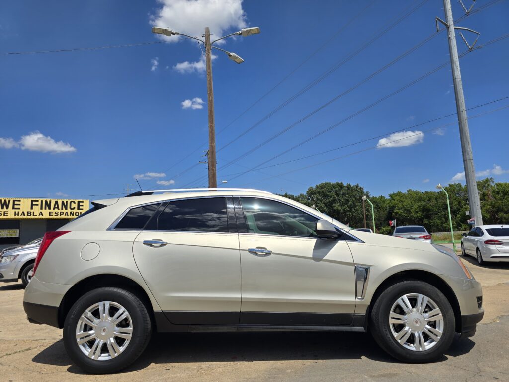 White SUV parked in a dealership lot under a bright blue sky with power lines overhead; a yellow sign reads 'WE FINANCE' in the background.