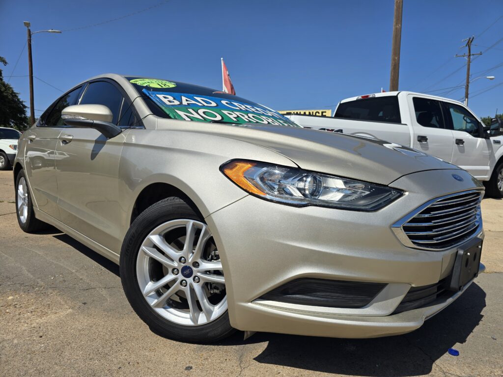 Silver sedan on a car lot with a large green windshield sign that reads 'BAD CREDIT NO PRO...' (sales promotion)